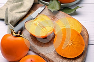 Delicious ripe juicy persimmons on wooden board, closeup