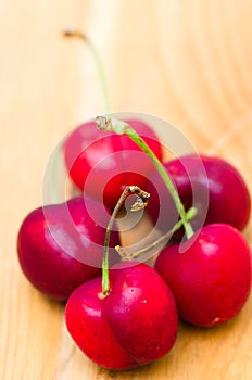 Delicious ripe red cherries on wooden surface photo
