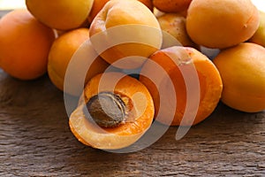 Delicious ripe whole and cut apricots on wooden table, closeup