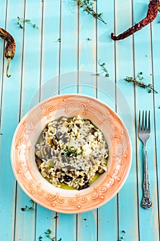 Delicious risotto with porcini mushrooms over wooden turquoise background