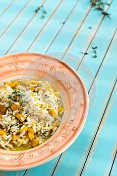 Delicious risotto with ripe pumpkin over wooden turquoise background
