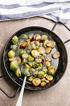 Delicious roasted brussels sprouts with beans and peanuts on grey marble table, top view