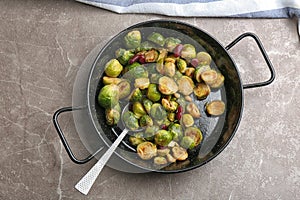 Delicious roasted brussels sprouts with red beans and peanuts on grey marble table