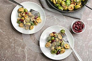 Delicious roasted brussels sprouts with red beans and peanuts served on grey marble table