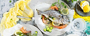 Delicious roasted dorado or sea bream fish with lemon and fresh Prawns