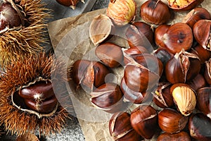 Delicious roasted edible chestnuts on grey table, flat lay