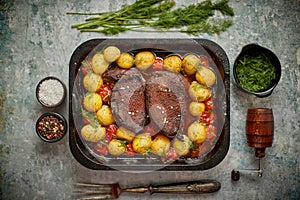 Delicious roasted goose breast served with vegetables, potatoes. Placed in metal baking dish