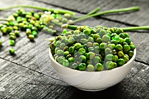 Delicious roasted green peas in white bowl.