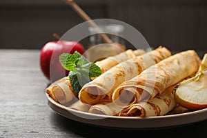 Delicious rolled thin pancakes on table