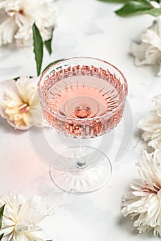 Delicious Rose sweet wine in glass with Peony Flowers on white background, Summer drink for party, wine shop or wine tasting