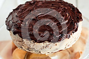 Delicious round cake with white buttercream topped with chocolate frosting, coating