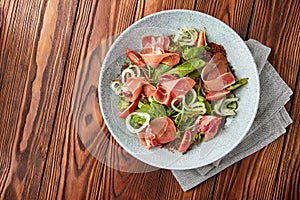 Delicious salad with prosciutto, mix of salads and tomatoes