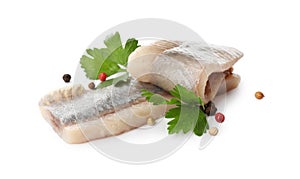 Delicious salted herring fillets with parsley and peppercorns on white background