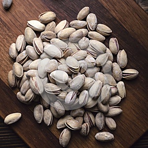 Delicious salted pistachios on wooden background