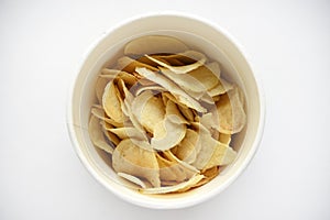 Delicious salted potato chips in a cardboard jar on a white background. Fast food