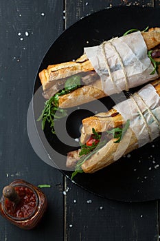 Delicious sandwich with meat with arugula and tomatoes