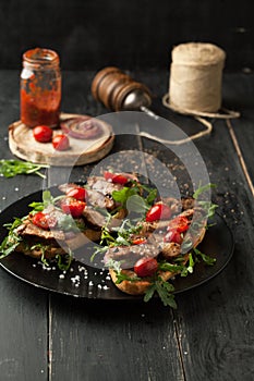 Delicious sandwich with meat with arugula and tomatoes