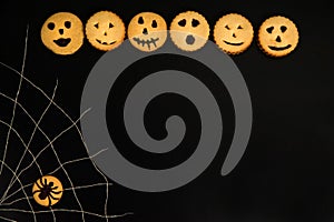 Delicious and scary smiley cookies, spider web, cookies with spider on black background.