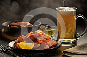 Delicious scene with steaming plate of hot fried shrimps and glass of beer