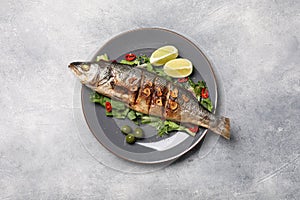 Delicious sea bass fish and ingredients on light grey table, top view