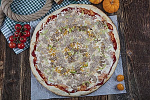 Delicious seafood pizza with tuna fish olive and pepper. Tuna pizza with vegetables on a wooden table. Healthy replacement for a