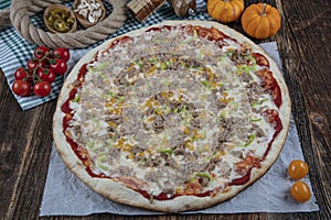 Delicious seafood pizza with tuna fish olive and pepper. Tuna pizza with vegetables on a wooden table. Healthy replacement for a