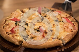 Delicious seafood pizza on a wooden textured table