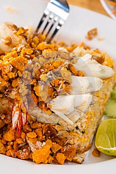 Delicious seafood thai fried rice (crab meat, shrimp, crab roe and squid) closeup