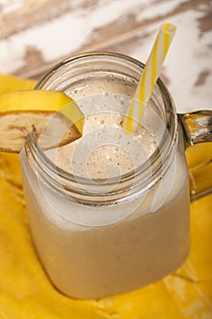 Delicious shake in cup with slice of banana