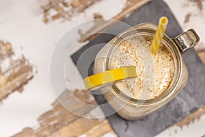 Delicious shake in cup with slice of banana