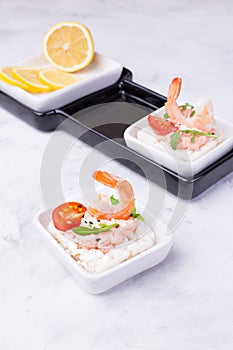 Delicious shrimp canapes with tomato and arugula on a light background. Festive appetizer with seafood