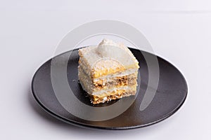 Delicious slice of Plazma cake on a matte dark grey plate on a white background