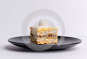 Delicious slice of Plazma cake on a matte dark grey plate on a white background photo