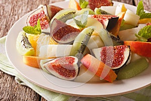 Delicious sliced fruit fig, peach, melon, kiwi and orange close-