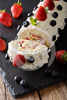 Delicious sliced strawberry cake with whipped cream, mint and bl