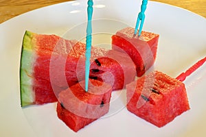 Delicious slices of ripe watermelon lie on a white plate