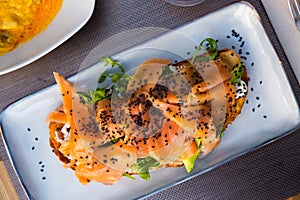 Delicious smoked salmon with arugula avocado and seeds on fried bread