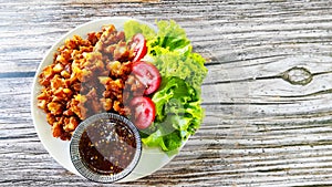 Delicious snack menu, fried chicken tendon served with green salad and sweet chilli sauce.