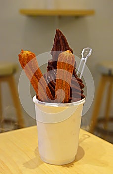 Delicious Soft serve ice cream chocolate flavour and churros with foggy effect photo