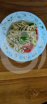 delicious spaghetti aglio olio topped with tuna and peppers