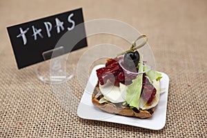 Delicious Spanish tapas, with a rustic mozzarella and dried tomato with olive. TAPAS poster .