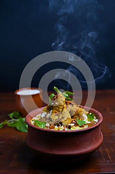 Delicious spicy chicken biryani , Indian or Pakistani ramzan food. on smoky background