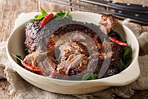 Delicious spicy slow shredded pulled pork closeup on a plate. horizontal