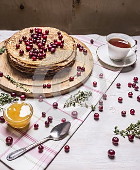 Delicious stack of pancakes with honey, berries and Herbal tea wooden rustic background close up