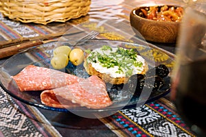Delicious starter in rustic restaurant with wine salami, olives, bread and cheese. Food concept