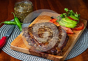 Delicious steak with green sauce and avocado photo