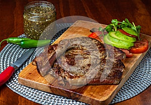 Delicious steak with green sauce and avocado photo