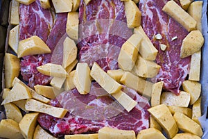 delicious steaks with baked potatoes, ready to go into the oven