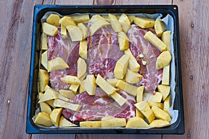 delicious steaks with baked potatoes, ready to go into the oven