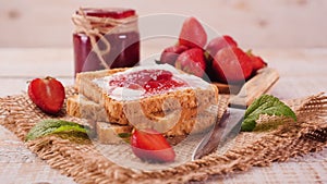 Delicious strawberry jam with fresh fruit and bread slices